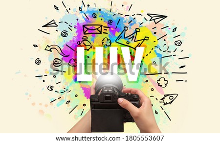 Close-up of a hand holding digital camera with abstract drawing and LUV inscription