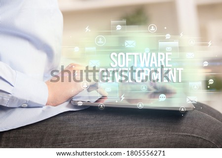 Close-up of a tablet searching SOFTWARE DEVELOPMENT inscription, modern technology concept