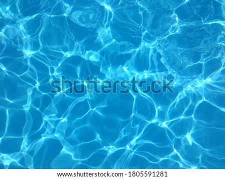 Blue water of a swimming pool in summer with reflections of sunlight in rippling waves Royalty-Free Stock Photo #1805591281