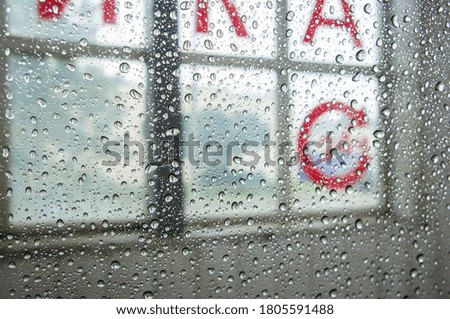 Water drop texture on transparent glass with letters on background