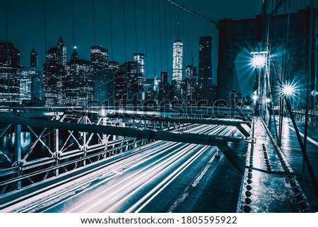 On Brooklyn Bridge at night with car traffic, NY, USA.