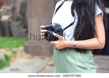 camera in the hand of a woman photographer