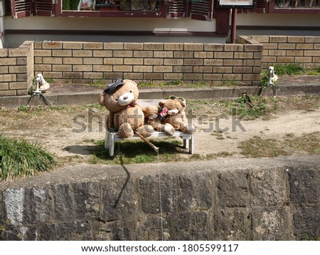 Three stuffed bears sitting on a bench  and fishing
