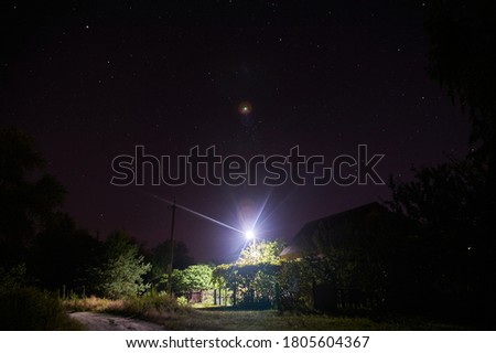 a house in the village under the starry sky lit by a lantern