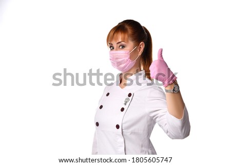 Confident young female doctor infectionist wearing medical facial mask and gloves showing thumbs up. Healthcare and medicine. Personnel health. Fighting disease covid19 virus. Headshot studio portrait