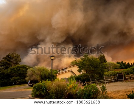 The California "River Fire" of Salinas,  in Monterey County, was ignited by dry lightning on August 16, 2020, fills the sky with dark smoke and flames as it burns close to a houses on its first day.   Royalty-Free Stock Photo #1805621638