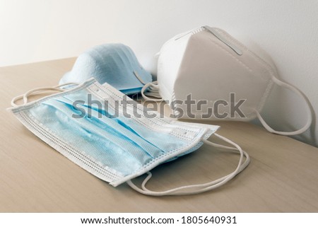 Corona virus prevetion face Mask protection N95 Masks and medical surgical Masks at home on white background and wooden table Royalty-Free Stock Photo #1805640931