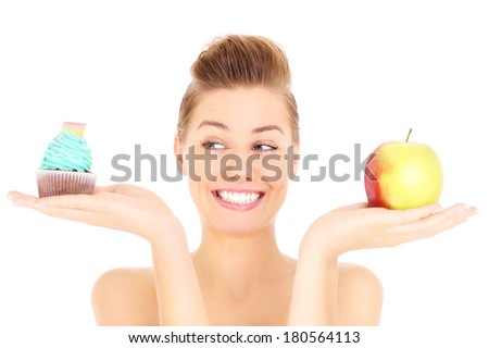 A picture of a woman trying to make a decision between cupcake and apple over white background