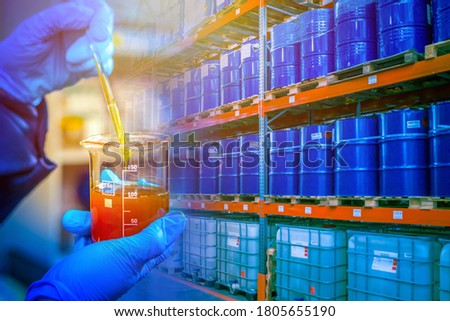 Warehouse chemical products. Concept - crude oil in blue barrels. Oil is prepared for export. Laboratory assistant took a sample for verification. Checking oil products for quality. Barrel shelving Royalty-Free Stock Photo #1805655190