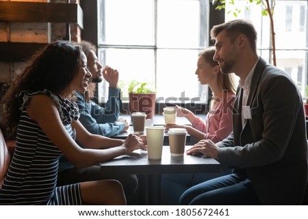 Diverse people sitting in cafe, drinking coffee and talking, chatting, participating in speed dating, young men and women having fun at meeting in coffee house, getting acquaintance Royalty-Free Stock Photo #1805672461