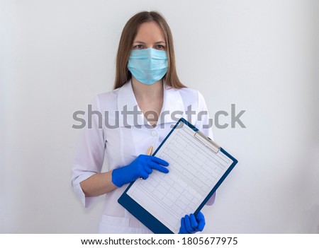 Examination and diagnosis heart, cardiogram. Doctor in white coat and silicone gloves and mask shows document of cardiogram.