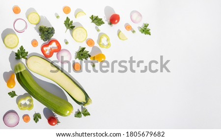 Composition of whole and sliced zucchini with vegetables on a white plate with space for text. Background with food. Royalty-Free Stock Photo #1805679682