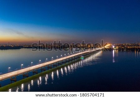 Evening photo of the automobile bridge over the blooming Dnieper river