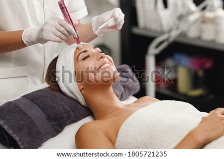 Shot of a beautiful young woman on a facial dermapen micro-needling treatment at the beauty salon. Royalty-Free Stock Photo #1805721235