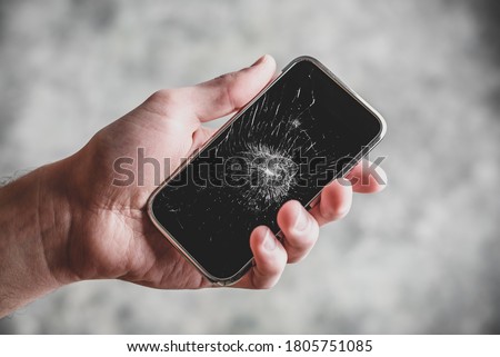 Smart cell phone with a broken screen in hand