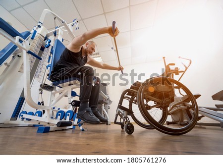 Disabled man doing strength exercises separate from the wheelchair.