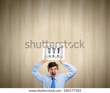 Young anxious businessman holding frame with exclamation marks