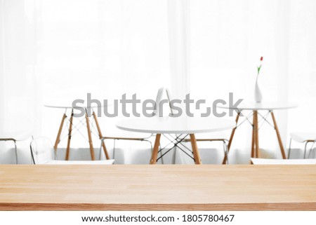 Empty wooden desk space and blurry background of cafe or Restaurant for product display montage.