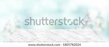 Perspective marble table with blur Christmas tree decorate string light and blue bokeh with snow light.Panoramic wooden countertop banner mock up for product display for online content