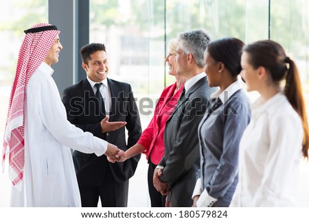 young translator introducing Arabian businessman to business partners
