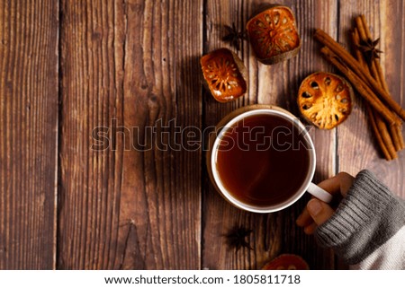 Autumn flat lay composition with tea cup and autumn dried fruits and leaves on vintage wooden table. Top view and copy space.