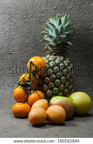 Pineapple fruits,apples and orange on a gray background , Close up