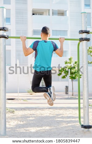 Man in sportswear training in a park doing strength exercises