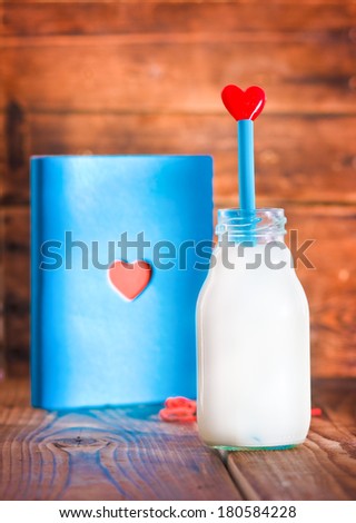 Notebook and bottle of milk with heart 