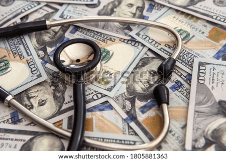 medical stethoscope lying on a lot dollar banknotes. care and finance concept