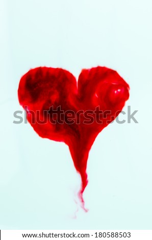 Red food coloring heart shape in white cream