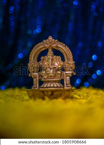 Closed up of Lord Ganesha in bronze with blue Bokeh background