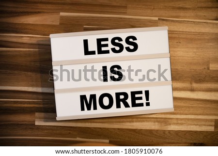 Lightbox or light box with business message Less is more on wooden background table