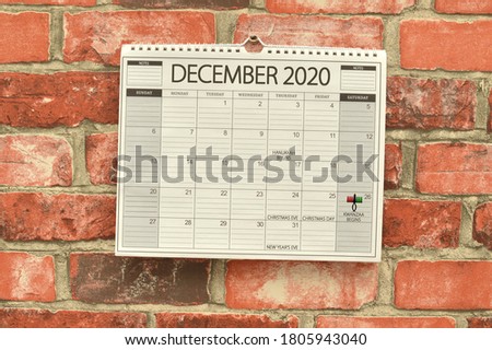Kwanzaa Begins December 2020 Calendar hanging on brick wall