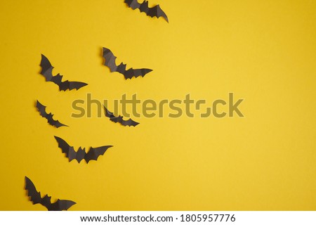 Halloween decoration concept black paper bats yellow cardboard background With copy space for tetxt 
