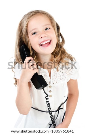 Adorable smiling little girl child speaking by old phone isolated on a white