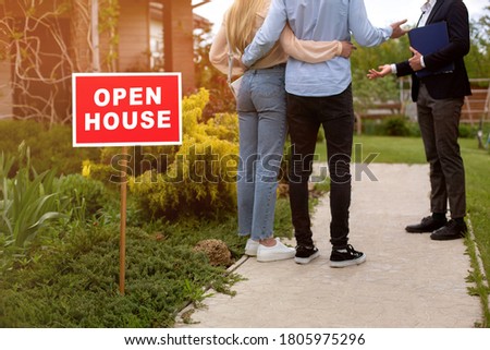 OPEN HOUSE sign and realtor showing potential buyers property for sale, outdoors. Cropped view