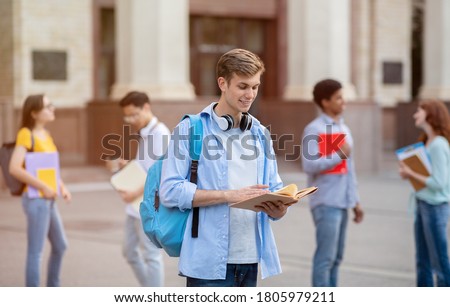 University Student Guy Reading Book Learning Standing Outside College Building. Getting Degree, Higher Education Concept