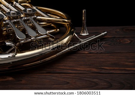 Musical instrument, French horn on a wooden surface on a black background Royalty-Free Stock Photo #1806003511