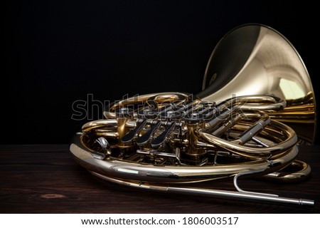 Musical instrument, French horn on a wooden surface on a black background Royalty-Free Stock Photo #1806003517