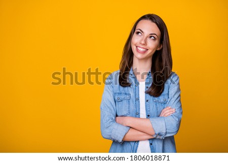 Photo of attractive confident young business lady arms crossed good mood skilled professional freelancer look up empty space dreamer wear denim shirt isolated vivid yellow color background