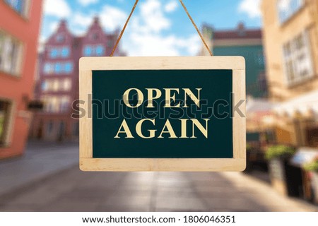 Open again sign board against open shop windows background.