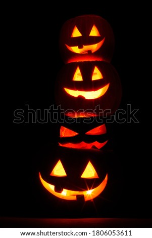 Pile of glowing Carved Halloween Pumpkins on black background