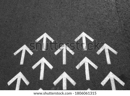 White upwards arrows on black asphalt road. conceptual background                               
