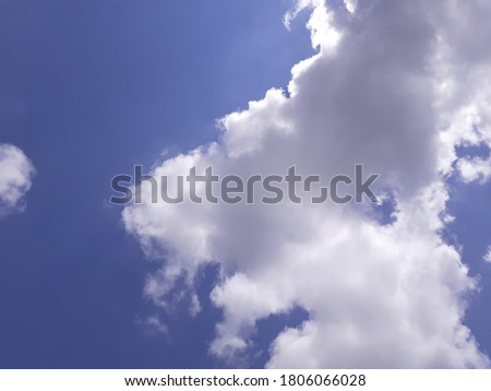 A beautiful view of the fluffy clouds - Image of white fluffy clouds illuminated by the sunlight behind them on a blue sky, natural beauty background.