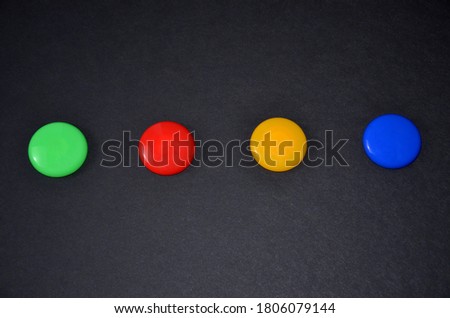 Multi-colored buttons on a black table.