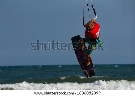 Kitesurfing on the waves of the sea in Mui Ne beach, Phan Thiet, Binh Thuan, Vietnam. Kitesurfing, Kiteboarding action photos. Kitesurf In Action 