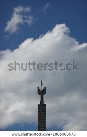 Fragment of a monument against a cloudy sky