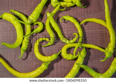Beautiful green chili peppers on a wooden surface, picture for design