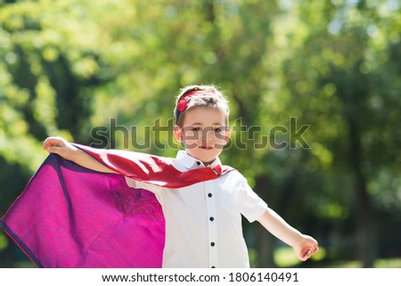 Child boy  in Superhero costume playing background nature. Copyspace. 