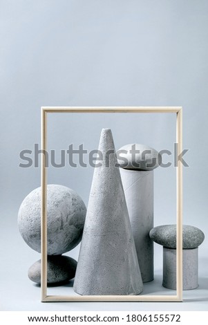 Abstract background with composition of different grey geometric objects, picture frame and stones. Copy space. Modern concept for product presentation.